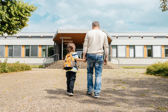 Dad escorts his child to school or kindergarten for the start of classes. Beginning of the school year. Parental care for children