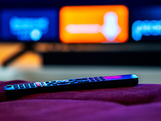 App TV remote on ottoman with TV with apps in background