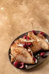 Chocolate crepes folded with Cherry and Whipped Cream on brown textured background rustic style with text space
