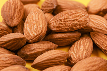 Almonds on a yellow background.  Macro photo.