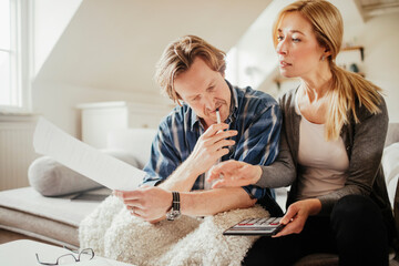 Mature couple going over their finances and bills at home while budgeting