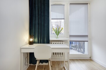 Jasna sypialnia z zielonym łózkiem i białym biurkiem do pracy - obrazy, fototapety, plakaty