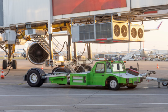 Green tug used to push or pull planes to parking slots or to runways. Very powerfull airport equipment.
