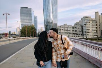 Fototapeta premium Young couple kissing in the middle of the city