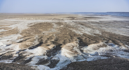 Panoramic view of the Kazakh steppe with ditches from the water and chalk slopes, the shape of limestones in the evening in the steppe