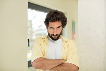 young crazy bearded man feeling displeased and disappointed, looking serious, annoyed and angry...