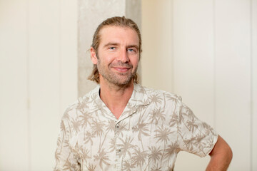 Obraz premium young blond adult man smiling happily with a hand on hip and confident, positive, proud and friendly attitude