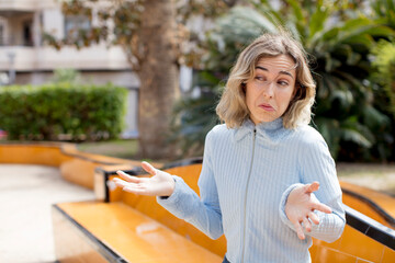pretty woman feeling puzzled and confused, unsure about the correct answer or decision, trying to...