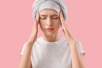 Teenage girl after chemotherapy suffering from headache on pink background, closeup