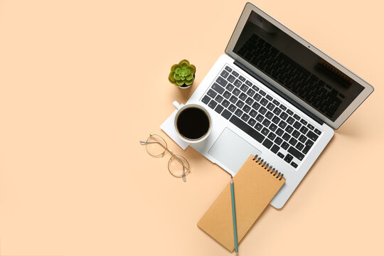 Composition with laptop, coffee and notepad on beige background