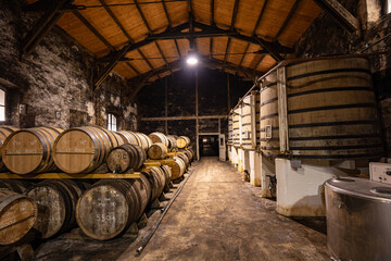 Tanks and barrels for aging cognac in French cellar.