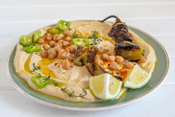 Chickpeas, baked hot pepper on hummus plate. Mediterranean food.