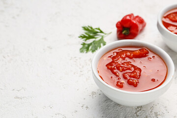 Bowl with tasty tomato sauce on light background
