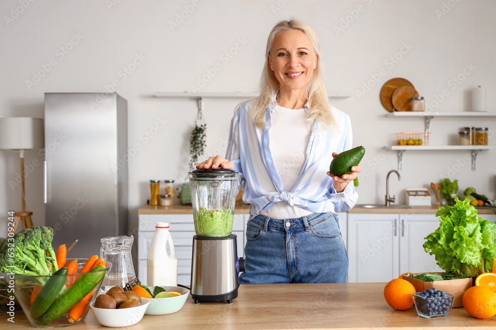 Sticker Mature woman making healthy smoothie with blender in kitchen