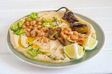 Chickpeas, baked hot pepper on hummus plate. Mediterranean food.