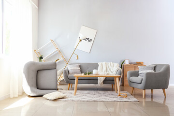Sofa with armchairs and table in messy living room