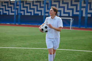 sports girl football player with a soccer ball on the soccer field, the concept of professional women's football