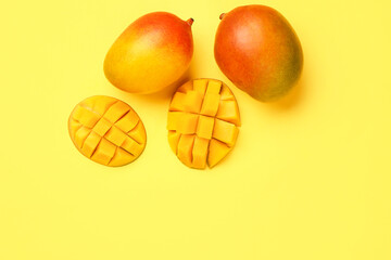 Fresh ripe mangoes on yellow background