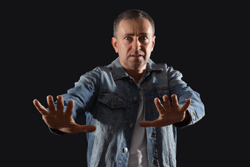 Mature man having panic attack on black background