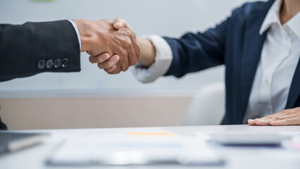 Executives business partnership handshake in meeting room..