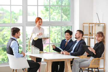 Obraz premium Secretary bringing water on job interview in office