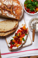 Bruschetta from homemade bread with cottage cheese and sprat pate and tomatoes on a wooden background. Rustic style.