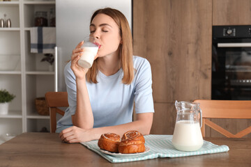 Young woman drinking milk in kitchen - Powered by Adobe