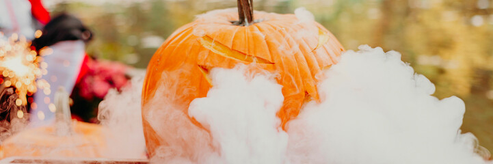 pumpkin carved with smoke in boat on pond in autumn, Halloween celebrating concept