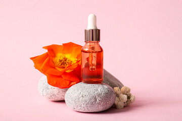 Composition with bottle of essential oil, stones and flowers on color background