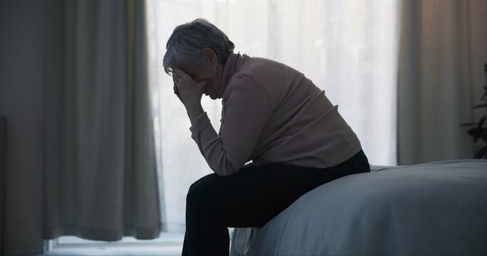 Stress, depression and sad old woman in bedroom with anxiety, mental health problem and debt in retirement. Lonely senior female person crying at home for headache, pain and fatigue of crisis in mind