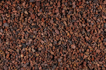 Natural aquarium lava gravel in red brown colors. Volcano lava mulch chippings mineral stones ground
