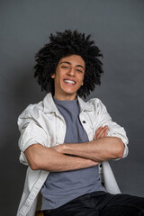 Young man sitting with arms crossed and looking confident