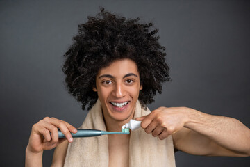 Young guy having morning procedures and brushing his teeth