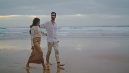 Loving couple going evening sea shore wide shot. Married people embracing ocean