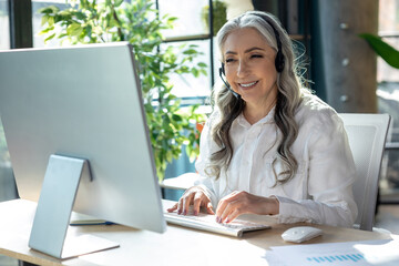 Good-looking mature business woman at the computrer looking busy