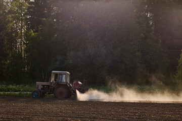 Tractor attached sprayer applies herbicides to soil to remove weeds and increase potato yields.