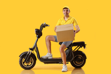 Fototapeta na wymiar Male courier with parcel and bike on yellow background