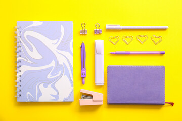 Different school stationery and notebooks on yellow background