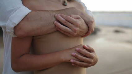 Couple hands embracing ocean beach closeup. Unknown woman man caress each other