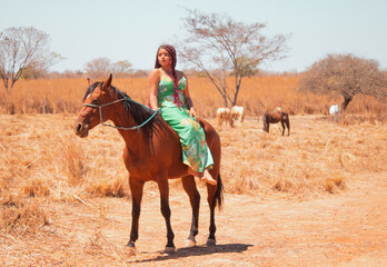Mulher de vestido longo a cavalo em uma fazenda no interior da Bahia-Brasil, na esta&ccedil;&atilde;o de outono.