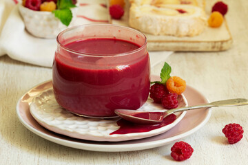 Raspberry curd, raspberries and meringue roll on a light background. Rustic style.