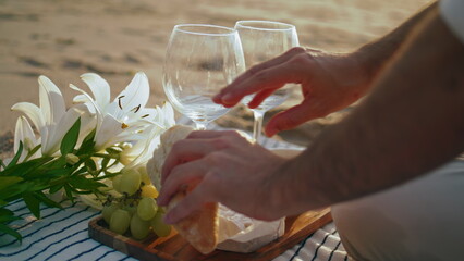 Man hands relaxing picnic on summer beach closeup. Unknown guy breaking bread