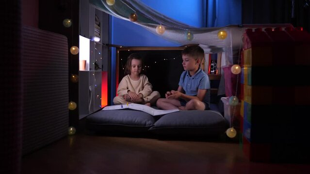 A Boy And A Girl Play A Board Game In A Makeshift House In The Apartment