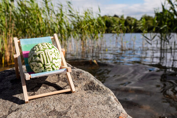 Brain on a sun bed in nature area. Positive effect of fresh air and sun on mind. Taking break from...