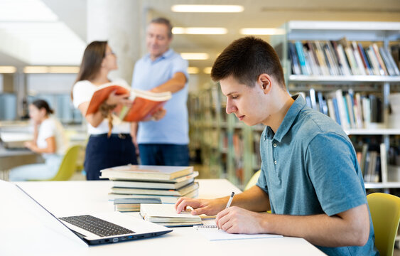 Smart male student preparing for the exam in the school library