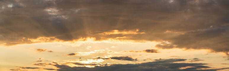 Naklejka na ściany i meble Cloudy sky at sunset with sunrays 