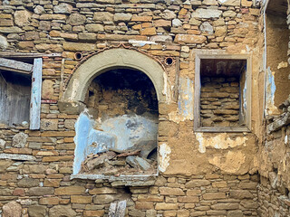 An antique stone fireplace and two niches next to it in a ruined house in Tepeköy, the Greek village of Gökçeada. Canakkale, Turkey
