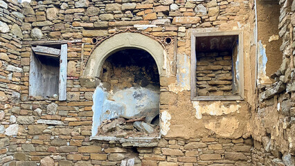 There is a stone fireplace and two niches next to it in a ruined house in Tepeköy, the Greek village of Gökçeada. Canakkale, Turkey
