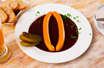Fresh portion of Viennese goulash with two sausages served on table.