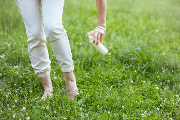 Closeup on woman using repellent spray